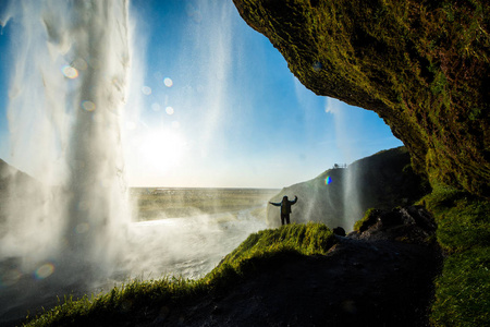 游客站在 Seljalandsfoss 在冰岛南部，Seljalandsfoss，冰岛最著名的瀑布之一