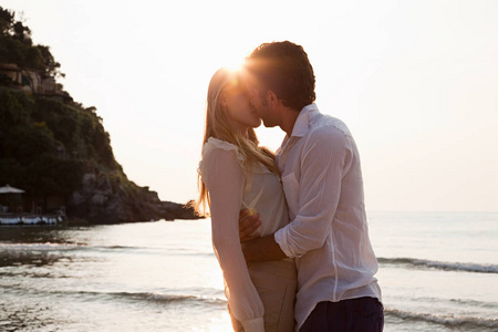 年轻夫妇在海滩上接吻