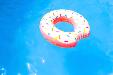 五颜六色的充气甜甜圈漂浮在水池