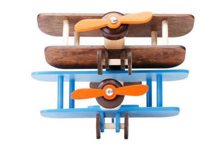 关闭两个木制玩具飞机孤立在白色背景上的图片。