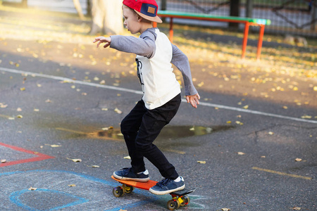 小城市男孩与一个便士滑板。年轻的孩子骑在 th