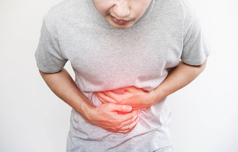 一个人捂着肚子，用红色突出显示肚子痛和其他胃疾病的概念，与副本空间的白色背景上