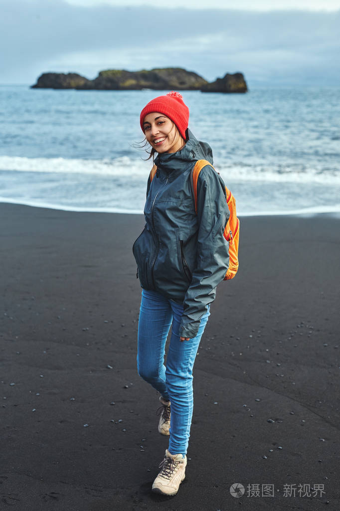 走在kirkjufjara 黑沙海滩,冰岛南部的女人