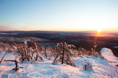 冬季景观。雪在群山中对抗美丽的日落