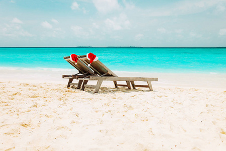 海滩上的圣诞节海上主持休息室与圣诞老人的帽子