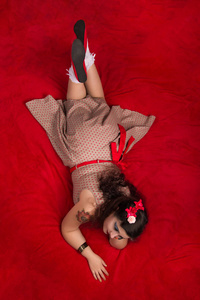 海报女孩摆在一张红床上