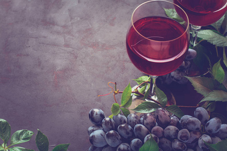 静物与酒杯 瓶 葡萄和褐色的木桌上的叶子