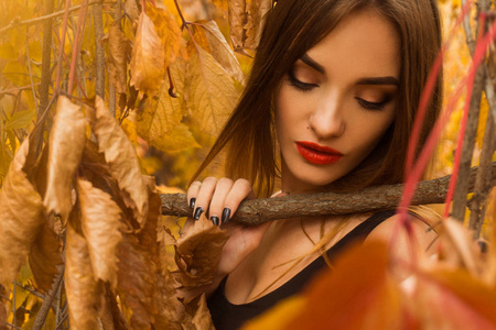 年轻的女孩，红红的嘴唇构成在秋天叶子