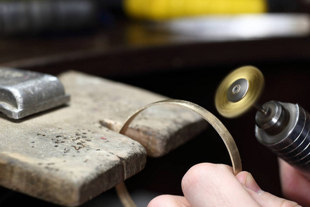 珠宝商工作与手镯抛光电机工具。珠宝首饰工作场所