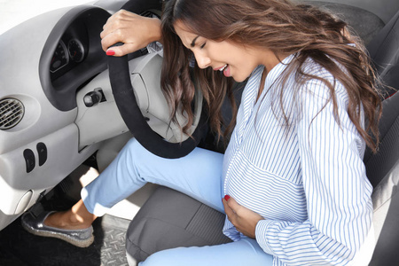 怀孕的年轻妇女在汽车