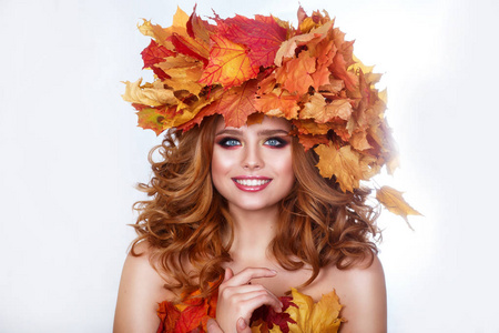 美女模型与明亮的秋天叶子发型。与秋季化妆和发型的美丽时尚女性。