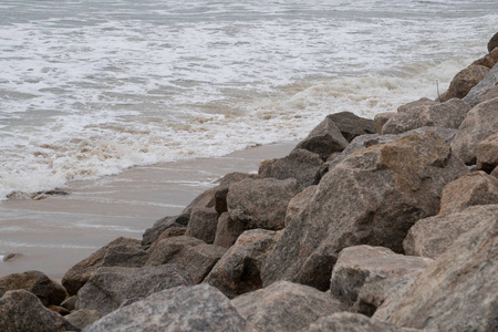 当海浪从水流中冲击时, 海岸海岸海滩上的大岩石排成了长队