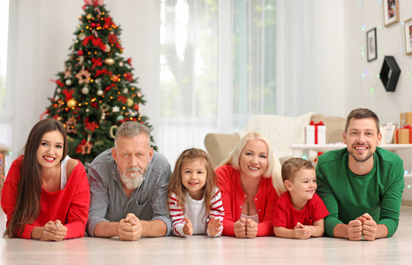 幸福的家庭躺在地板上在圣诞节装饰的房间