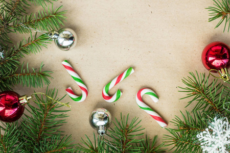 节日的圣诞边界与红色和银色的球冷杉树枝和雪花在质朴的米色背景