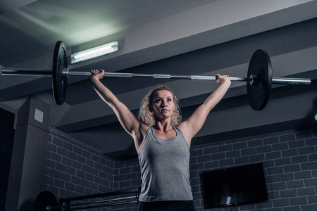 训练 crossfit 在健身房。女孩正在举重