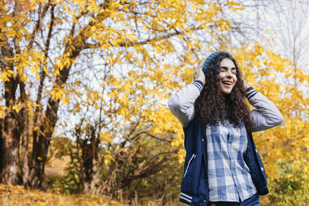 笑的女孩站立在秋天公园