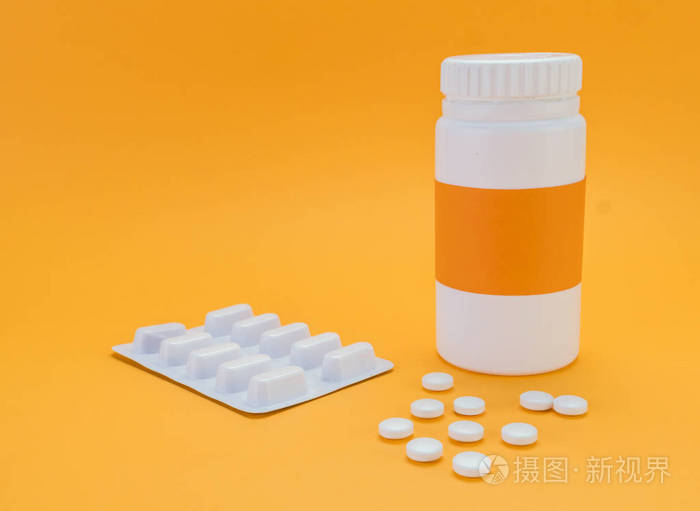 在橘色背景下开瓶的药片溢出