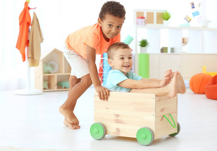 可爱的孩子们在室内玩木推车