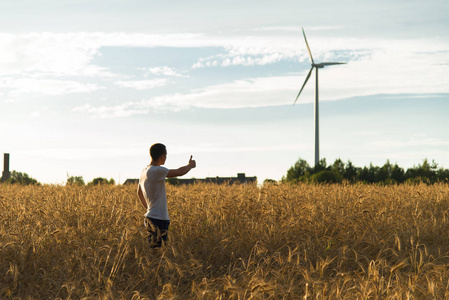 站在田野上看风力发电机的人图片