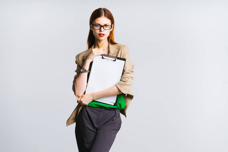 年轻成功的现代女孩戴着眼镜, 拿着文件夹着一个文件夹