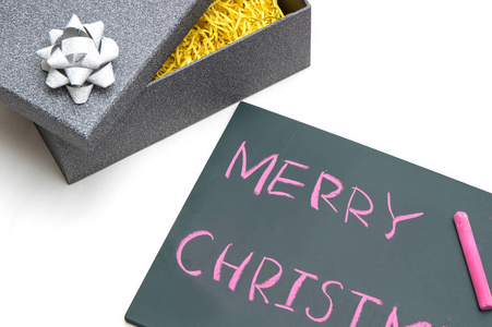 在黑板和礼物盒上的红色粉笔圣诞快乐