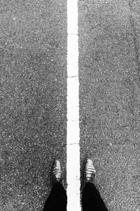 自拍脚和腿与白色线在具体路。黑白