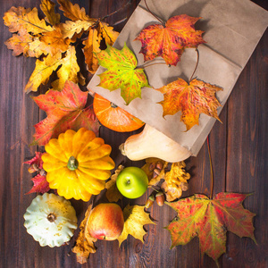 秋天自然概念。秋天南瓜和苹果在木制的质朴的桌子上。感恩节晚餐