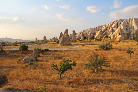 自然谷与火山凝灰岩石岩石在格雷梅在土耳其, 在日落