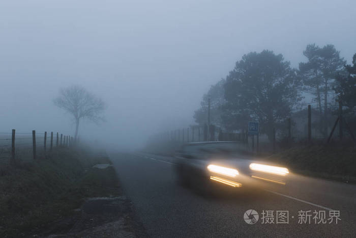 在雾蒙蒙的日子里的乡村风景.汽车大灯在晚上.色调