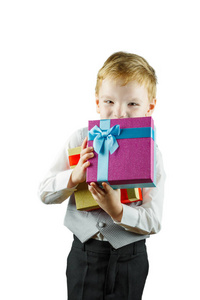 五岁的 redhaired 男孩手捧着两个带缎带和蝴蝶结的礼品盒白色背景