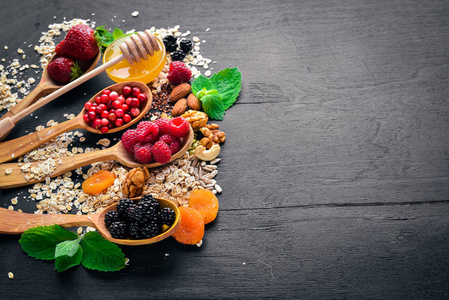 健康食品。新鲜的野果, 铜, 坚果, 燕麦片, 干果和种子。在木制背景上。顶部视图。文本的可用空间