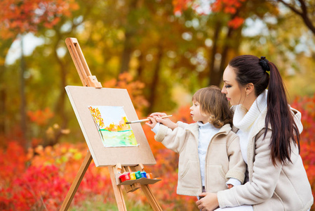 秋天的自然, 妈妈和女儿在公园里画了一幅秋叶, 画了一个小孩子, 孩子的创造力