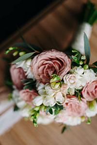 温柔的新娘花束，上面有玫瑰和牡丹，上面有结婚戒指