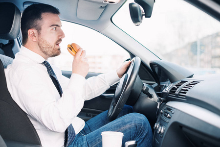 人吃育肥食物和驾驶坐在汽车