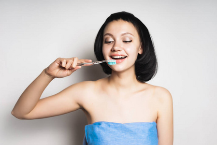 美丽的微笑的女孩与黑头发刷子牙