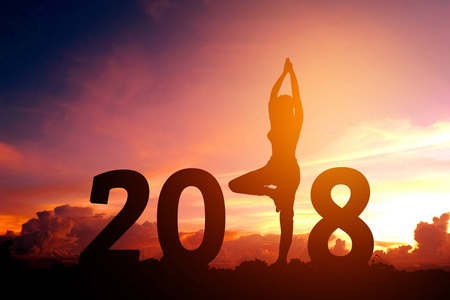 2018新年的剪影年轻妇女练习瑜伽