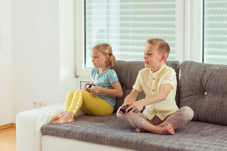 两个快乐的孩子们玩视频游戏在家里