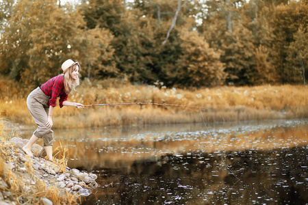 女孩在秋天与钓鱼竿