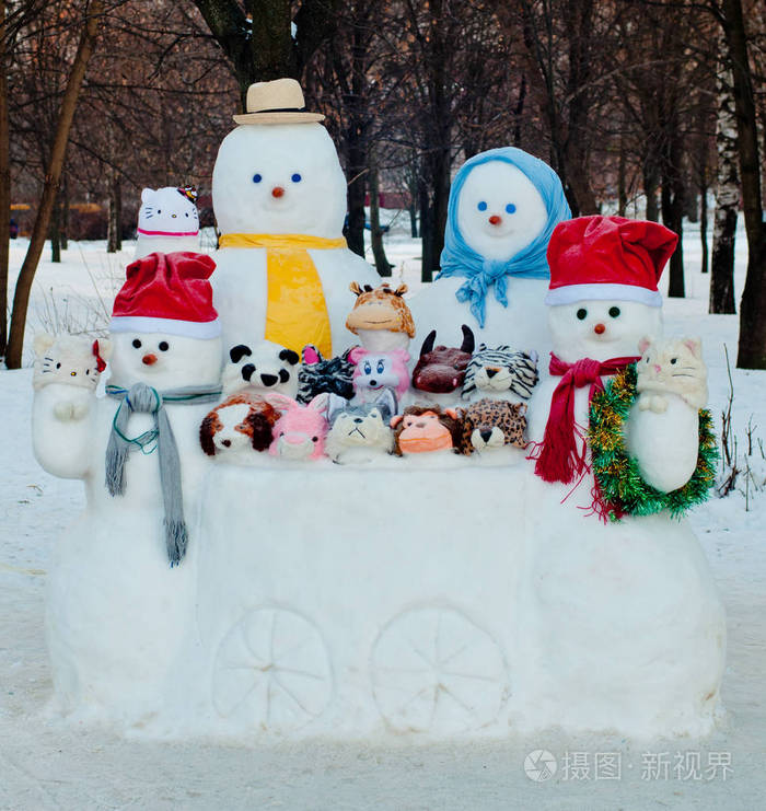 冬天,一群穿着不同尺寸的雪人和雪地动物在户外靠近树木