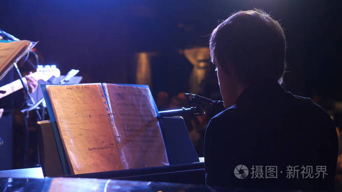 在豪华酒店弹钢琴的音乐表演者的背景