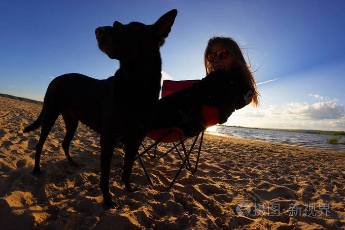 沙滩椅上的女孩和狗在海滩上