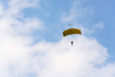 将军跳伞与开放黄色降落伞云彩蓝天背景