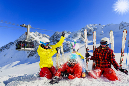 幸福的家庭享受寒暑假在山。滑雪太阳