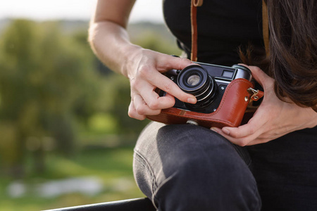年轻快乐的女摄影师带着复古相机在公园散步