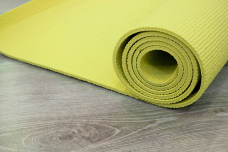 瑜伽垫子在木制地板上