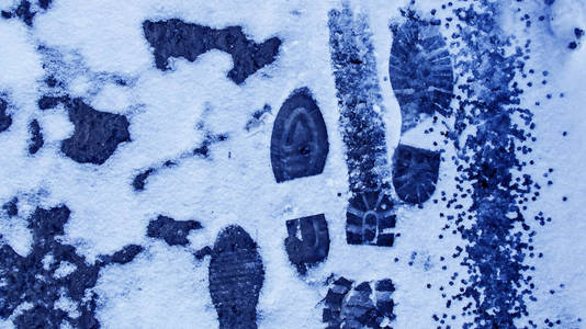 雪地里有肮脏的脚印从靴子上的轨道