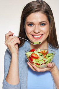 米黄色背景下年轻女性用叉子吃沙拉的肖像健康食品概念