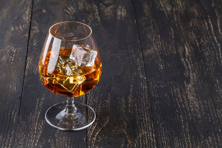 杯加冰块的威士忌送达木板。突出显示与一杯烈性酒的老式台面