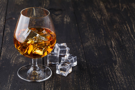 杯威士忌加冰上木制的背景