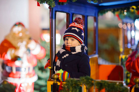孩子小孩子骑旋转木马在圣诞市场